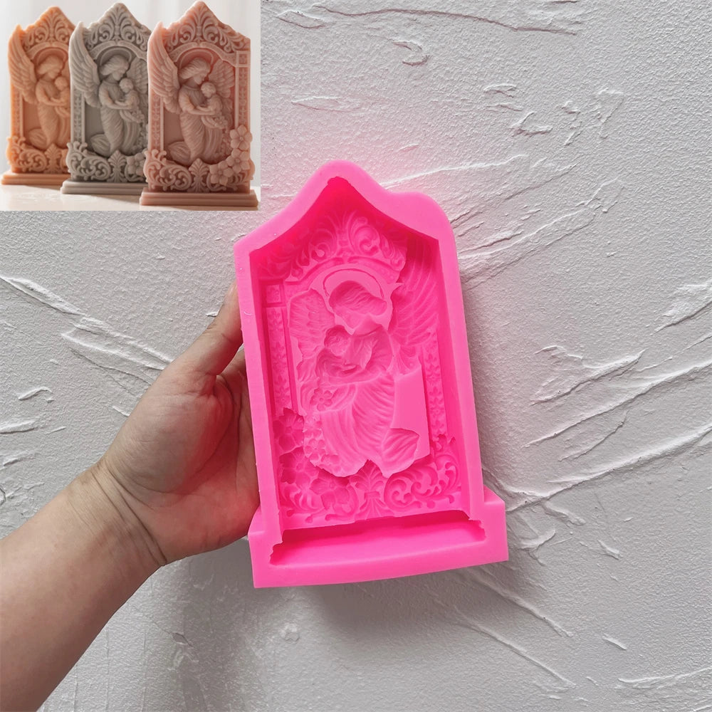 Pink mother-and-baby angel relief silicone mold held in one hand