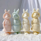 Four apron-wearing rabbit candle samples viewed from the front
