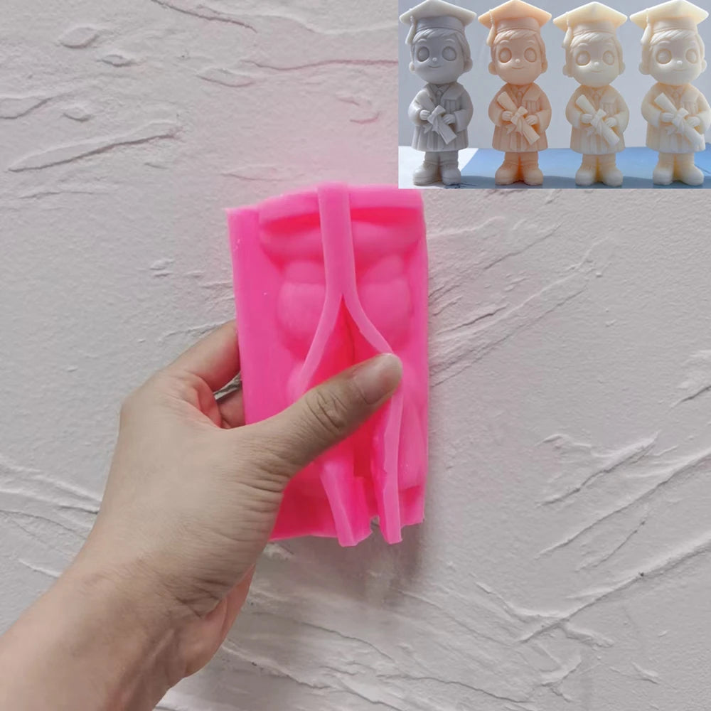 Pink boy graduate silicone mold held in one hand