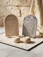 Close view of beige and gray arched Hebrew inscription plaques with floral relief