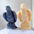 Two perched eagle sculptures on oval bases