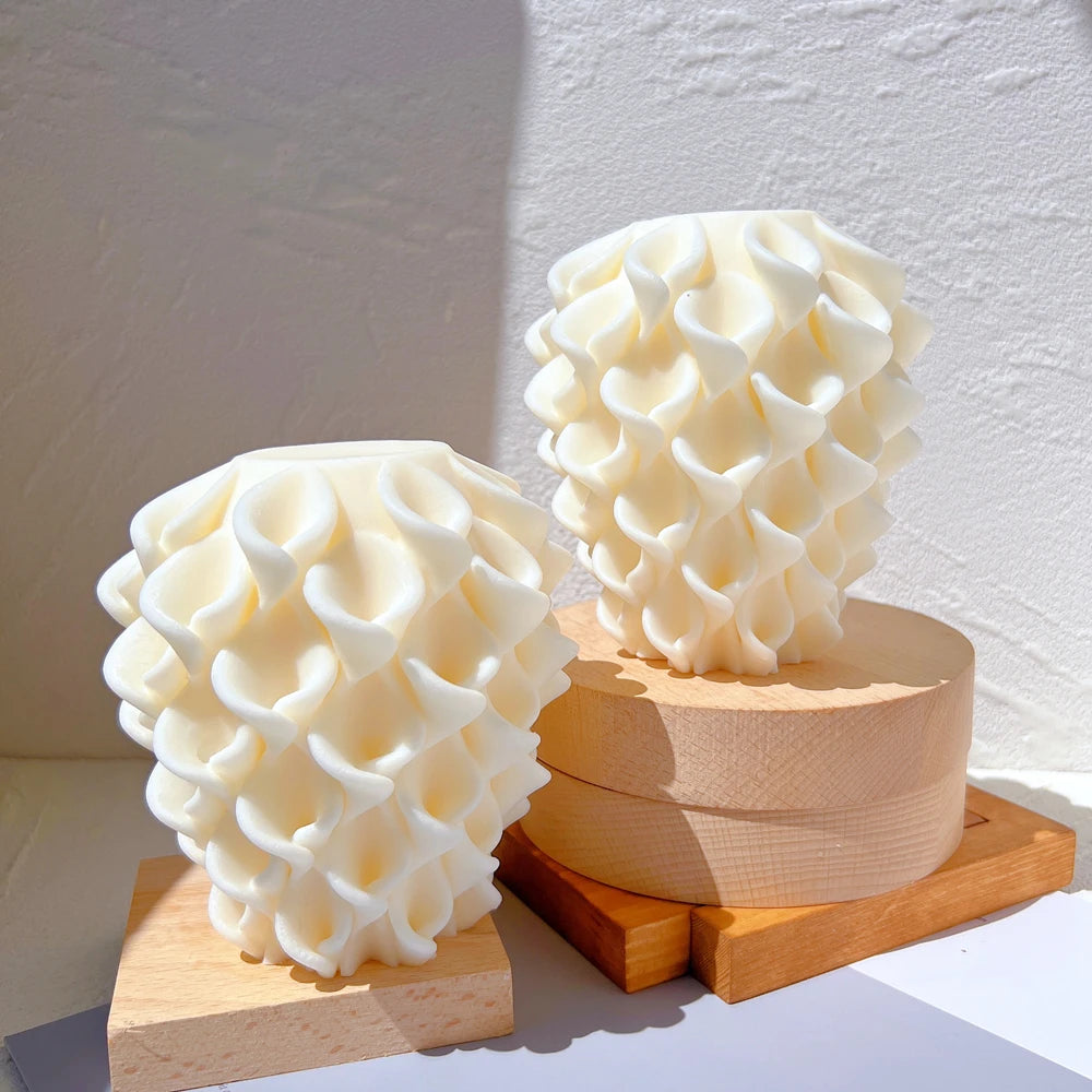 Petal-textured sculptural candle castings in two heights displayed on wooden blocks