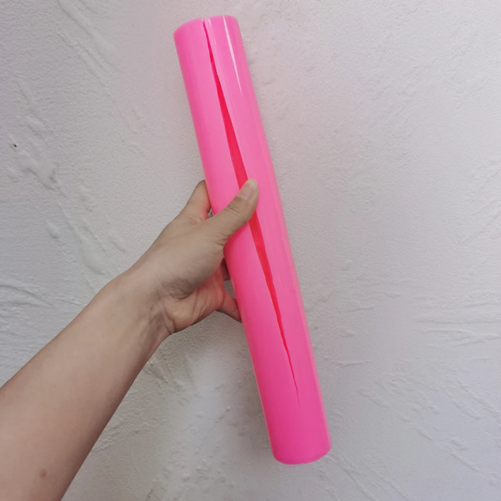 Pink ribbed waisted taper silicone mold held in one hand