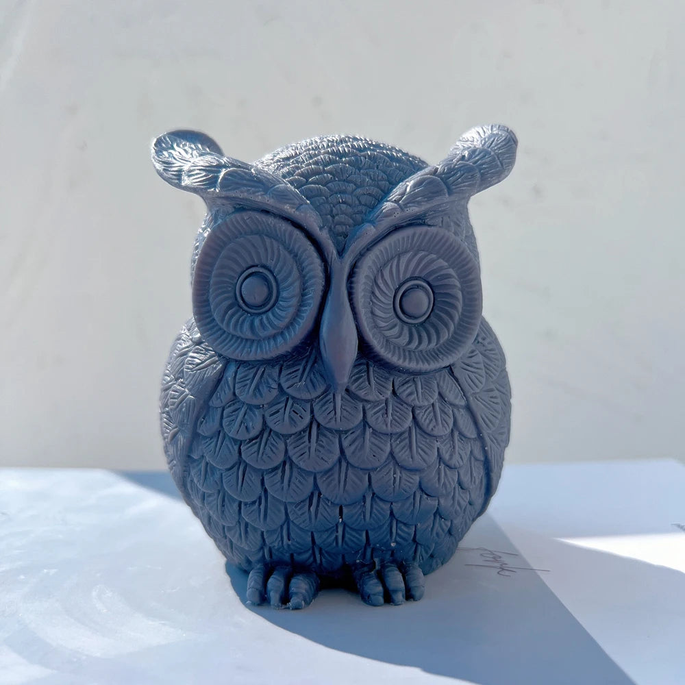 Single blue owl candle viewed from the front