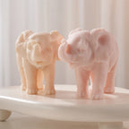 Peach and pink raised-trunk elephants on a display surface