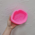 Pink lips silicone candle mold held in one hand