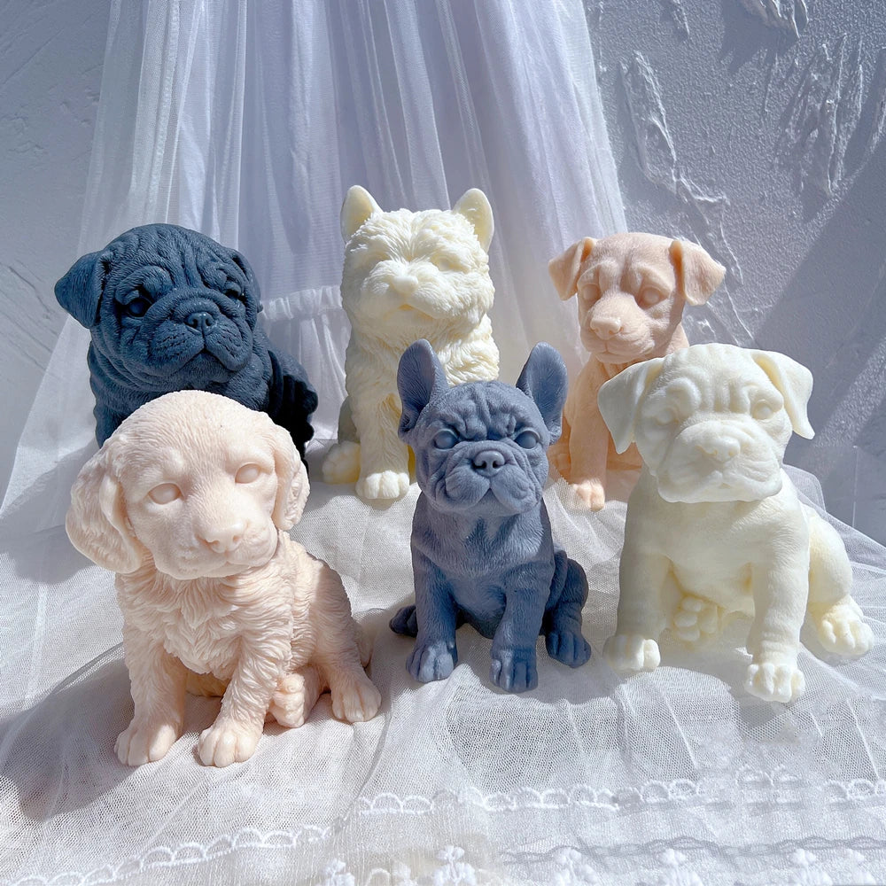 Group of sculpted puppy candles against white draped fabric