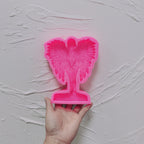 Pink silicone winged figure relief mold with integrated base cavity