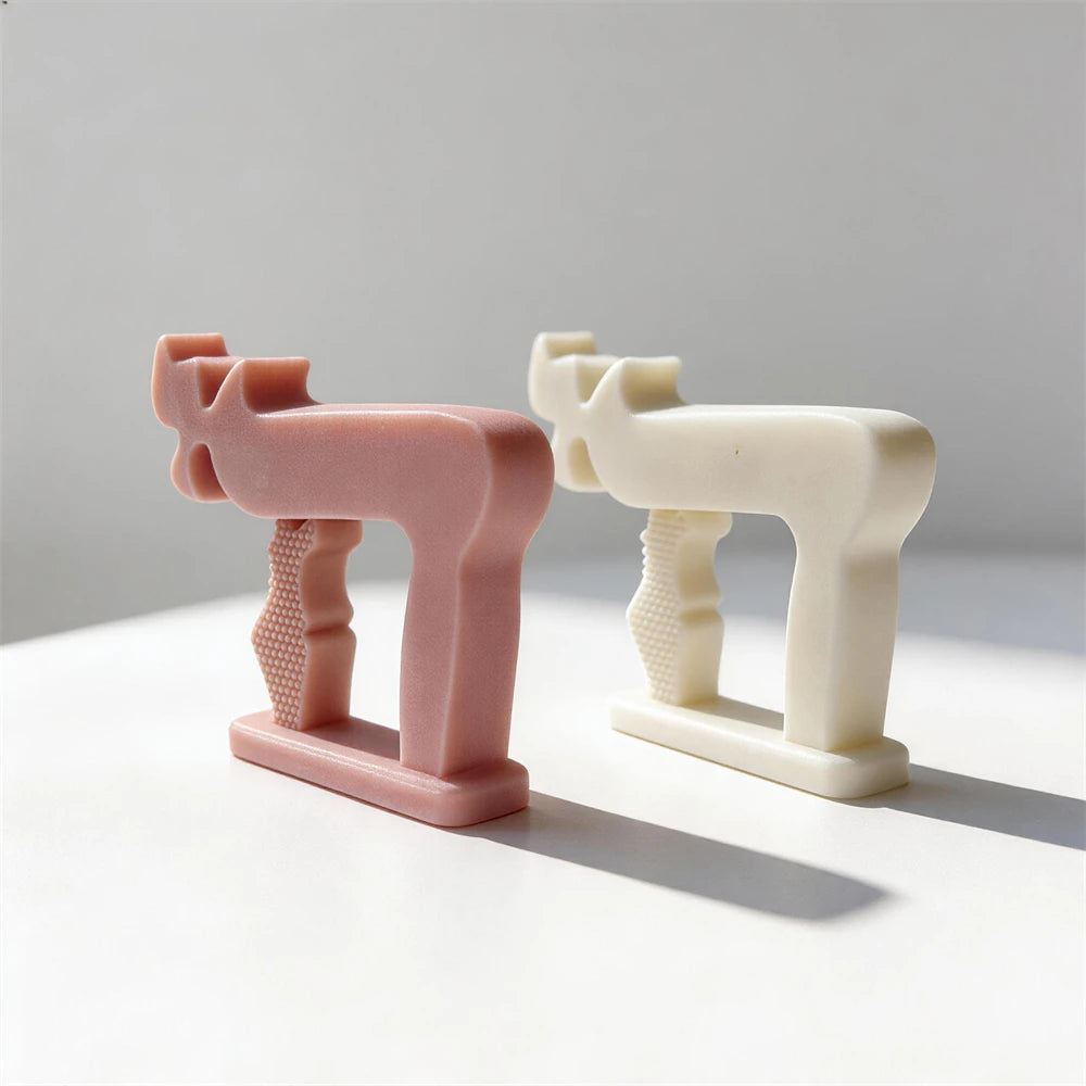 Pink and cream Chai symbol castings side by side
