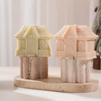 Short gingerbread cottage candles with pitched roofs on a display