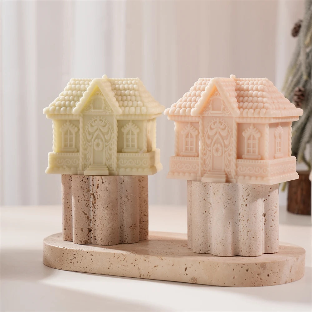 Short gingerbread cottage candles with pitched roofs on a display