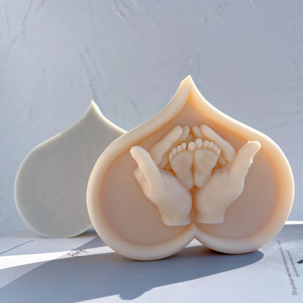 Close-up of curved heart outline and baby feet relief