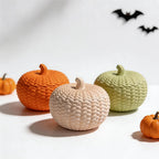 Three closed knitted pumpkin containers in autumn colors