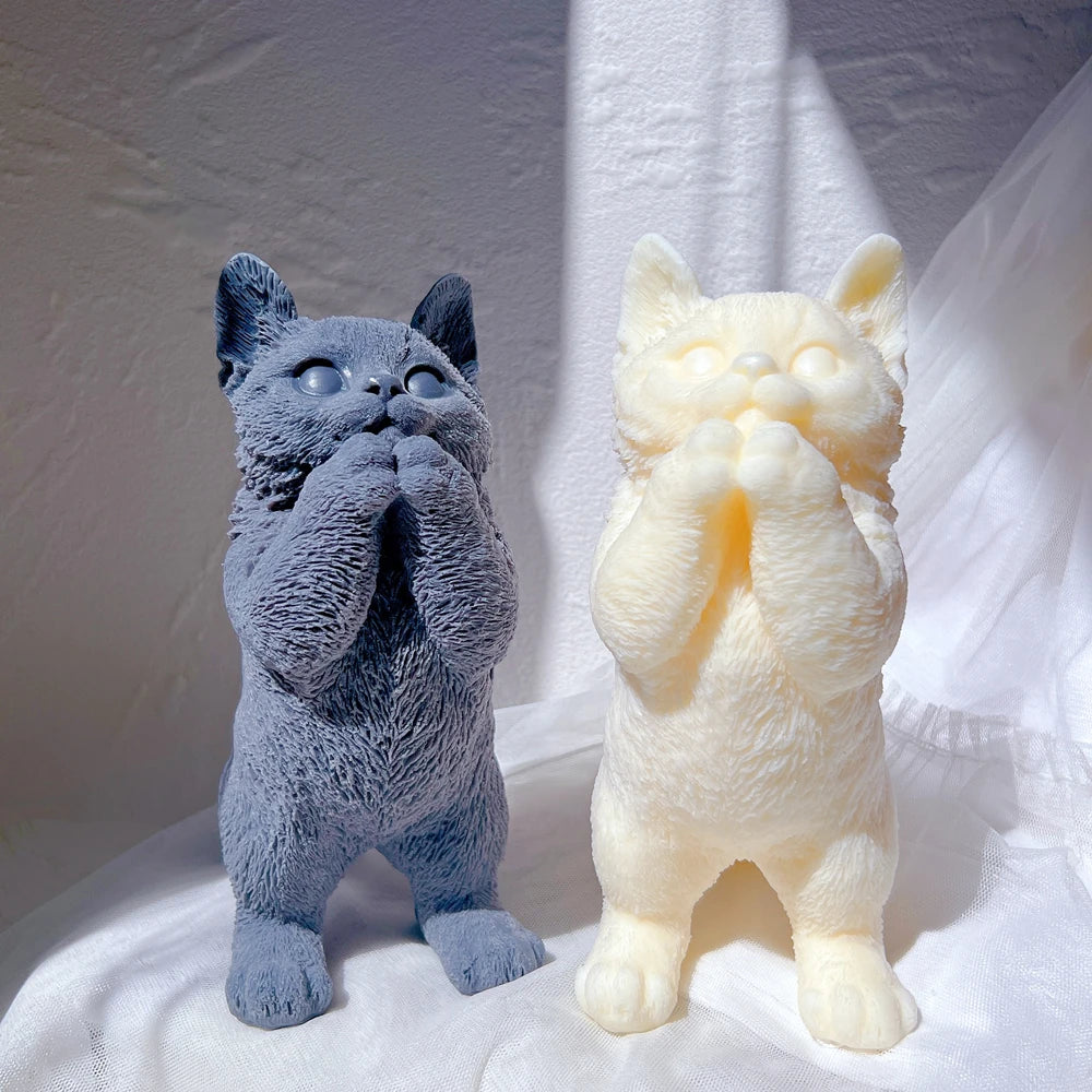 Dark blue and cream standing cat figures with paws raised beneath their faces