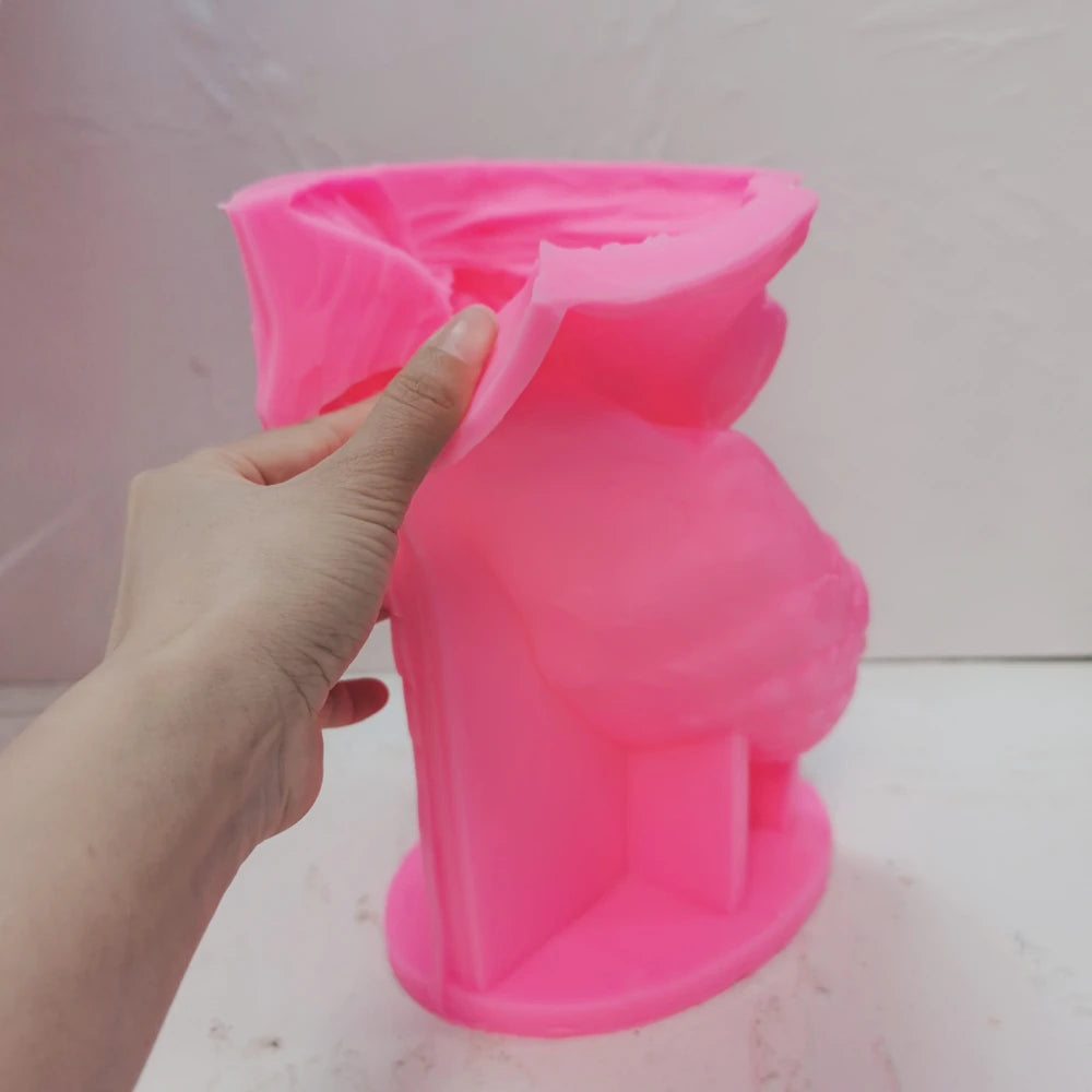 Pink perched-eagle silicone candle mold held in one hand