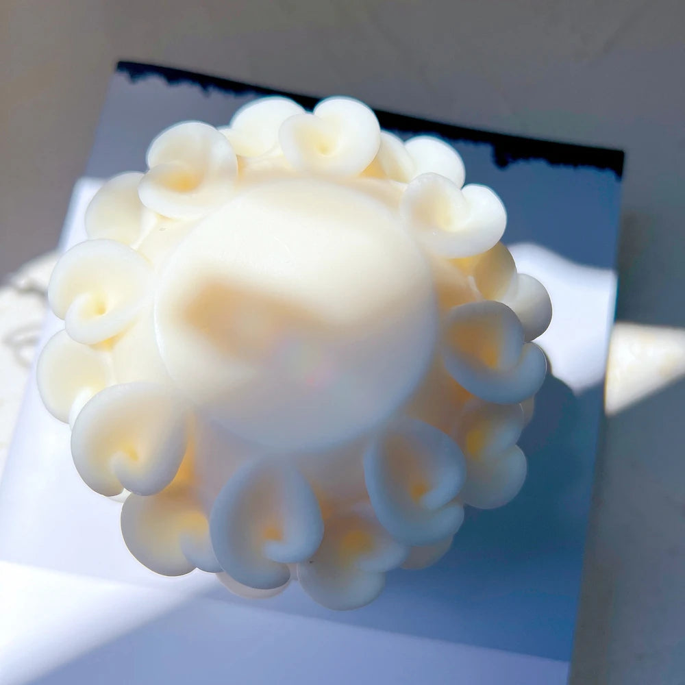 Overhead view of petal-textured candle casting and rounded upper surface