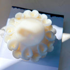 Overhead view of petal-textured candle casting and rounded upper surface