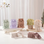 Several gingerbread house containers in pastel colors