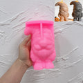 Pink silicone mummy gnome mold held in a hand