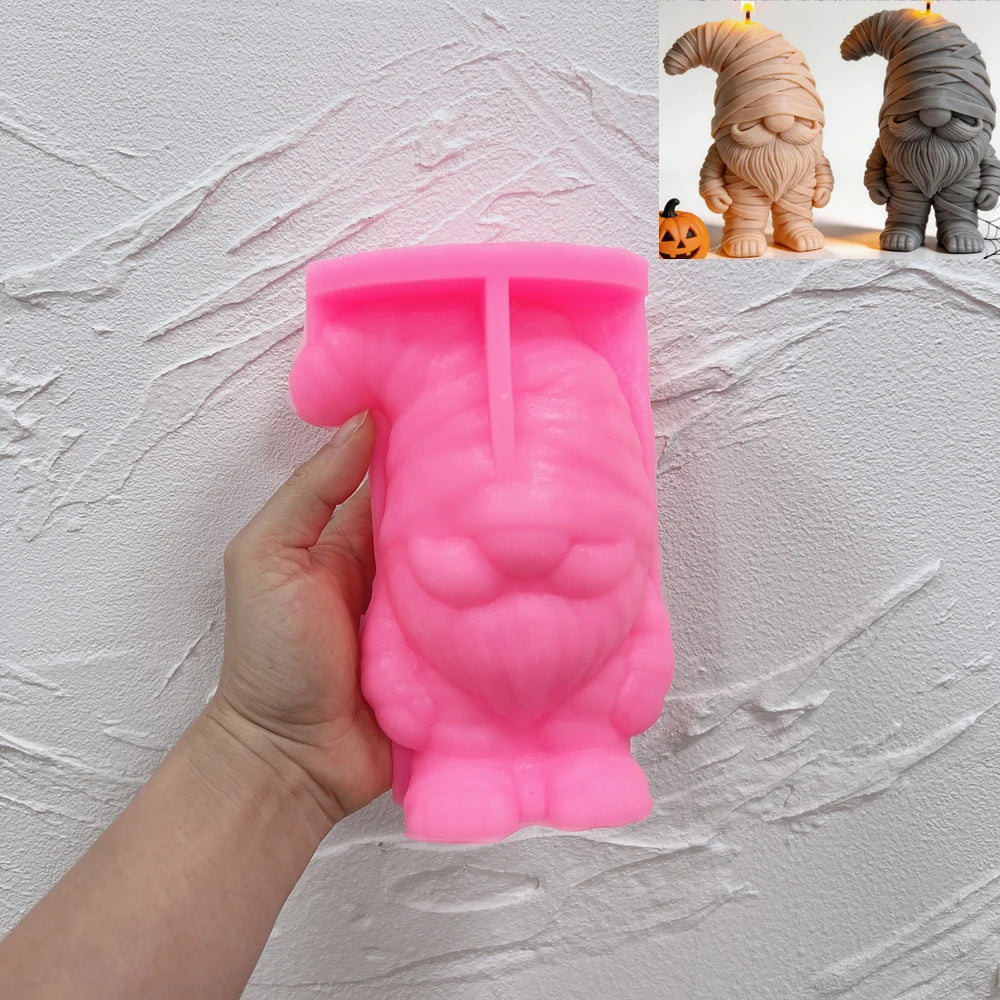 Pink silicone mummy gnome mold held in a hand