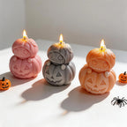 Pink grey and orange stacked pumpkin candles for Halloween