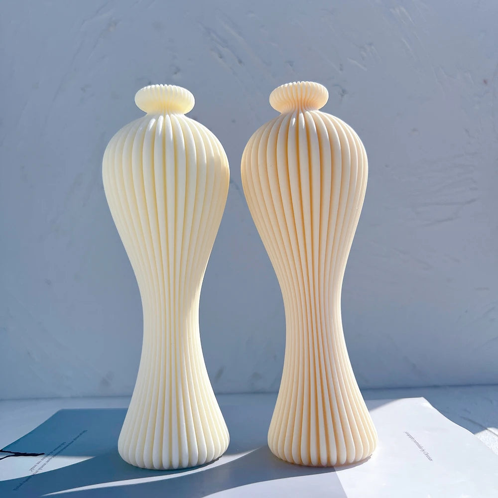 Two tall slender vase-shaped figures with vertical ribs
