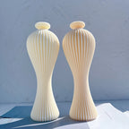 Two tall slender vase-shaped figures with vertical ribs