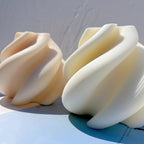 Two abstract spiral castings showing curved top folds