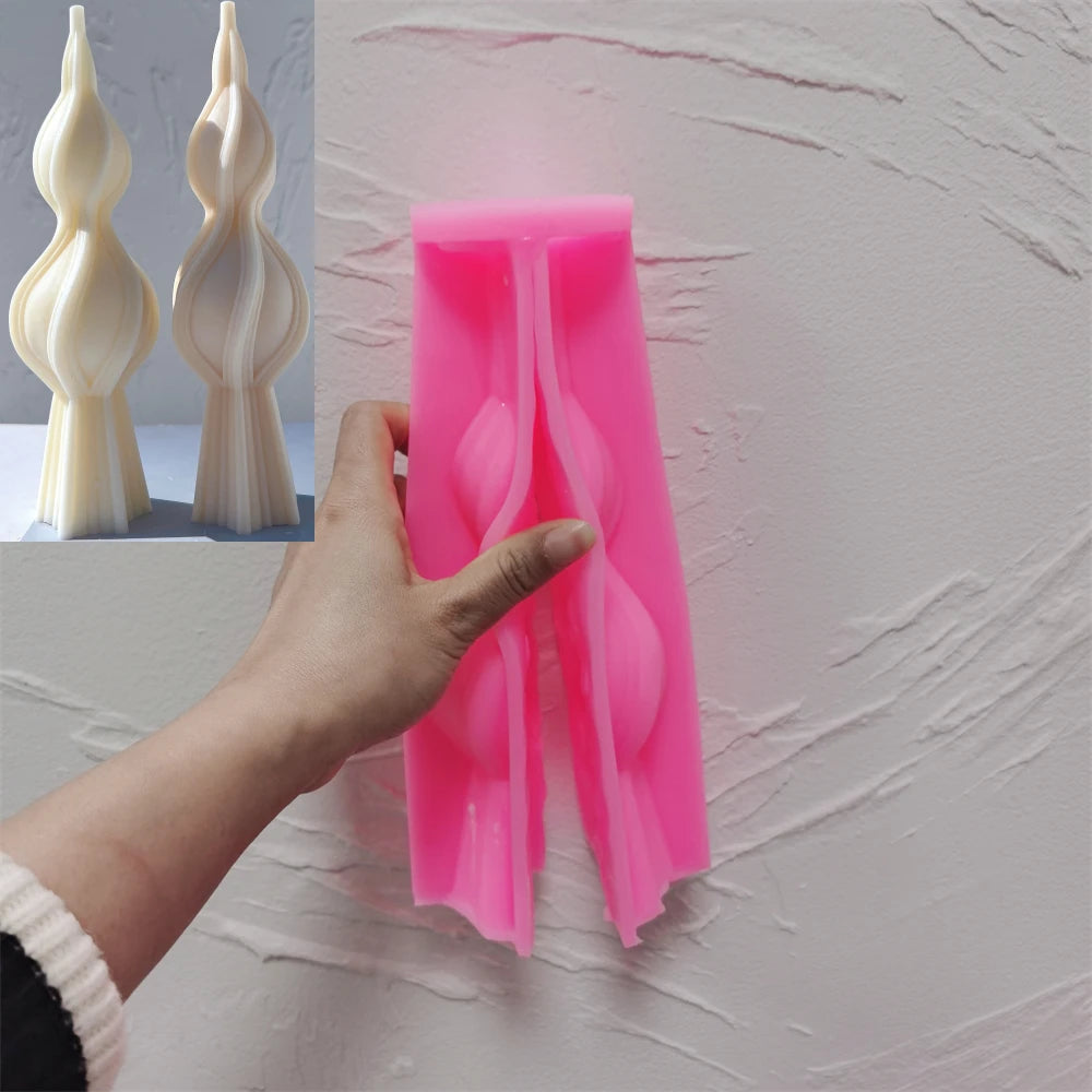 Pink twisted spindle silicone candle mold held in one hand
