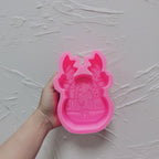 Pink antler-framed forest relief silicone mold held in one hand