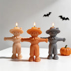 Cream, orange and gray scarecrow candles with outstretched arms and wide hats