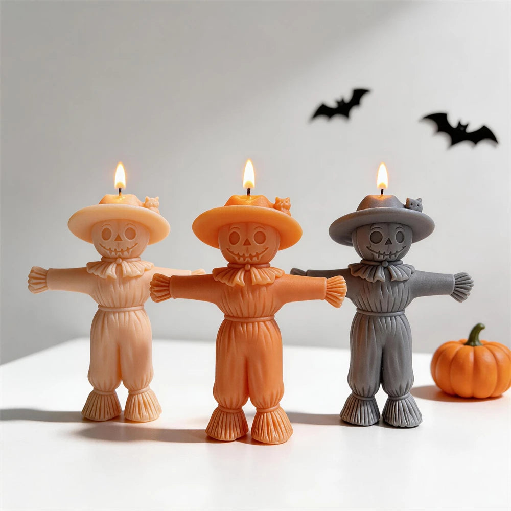 Cream, orange and gray scarecrow candles with outstretched arms and wide hats