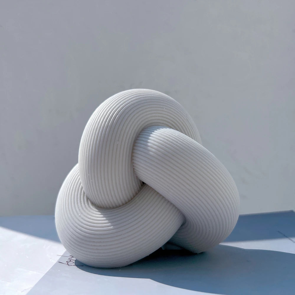 Gray ribbed tube knot candle with overlapping loops