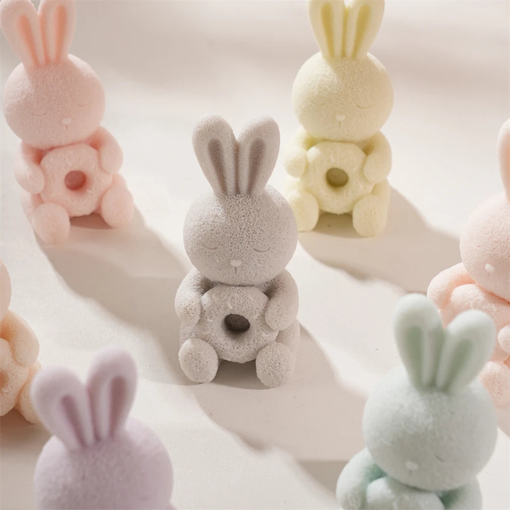 Pastel seated bunnies with flowers held in both paws