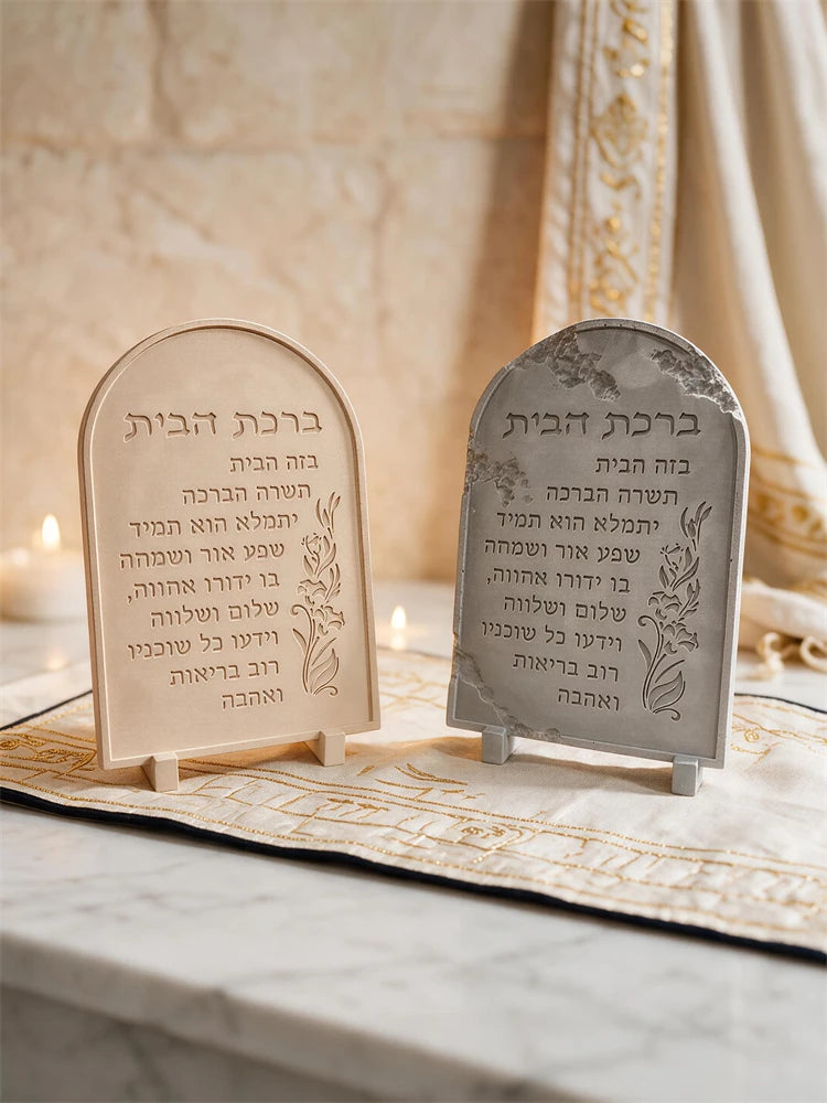 Close front view of two arched Hebrew lettering plaques and floral edges