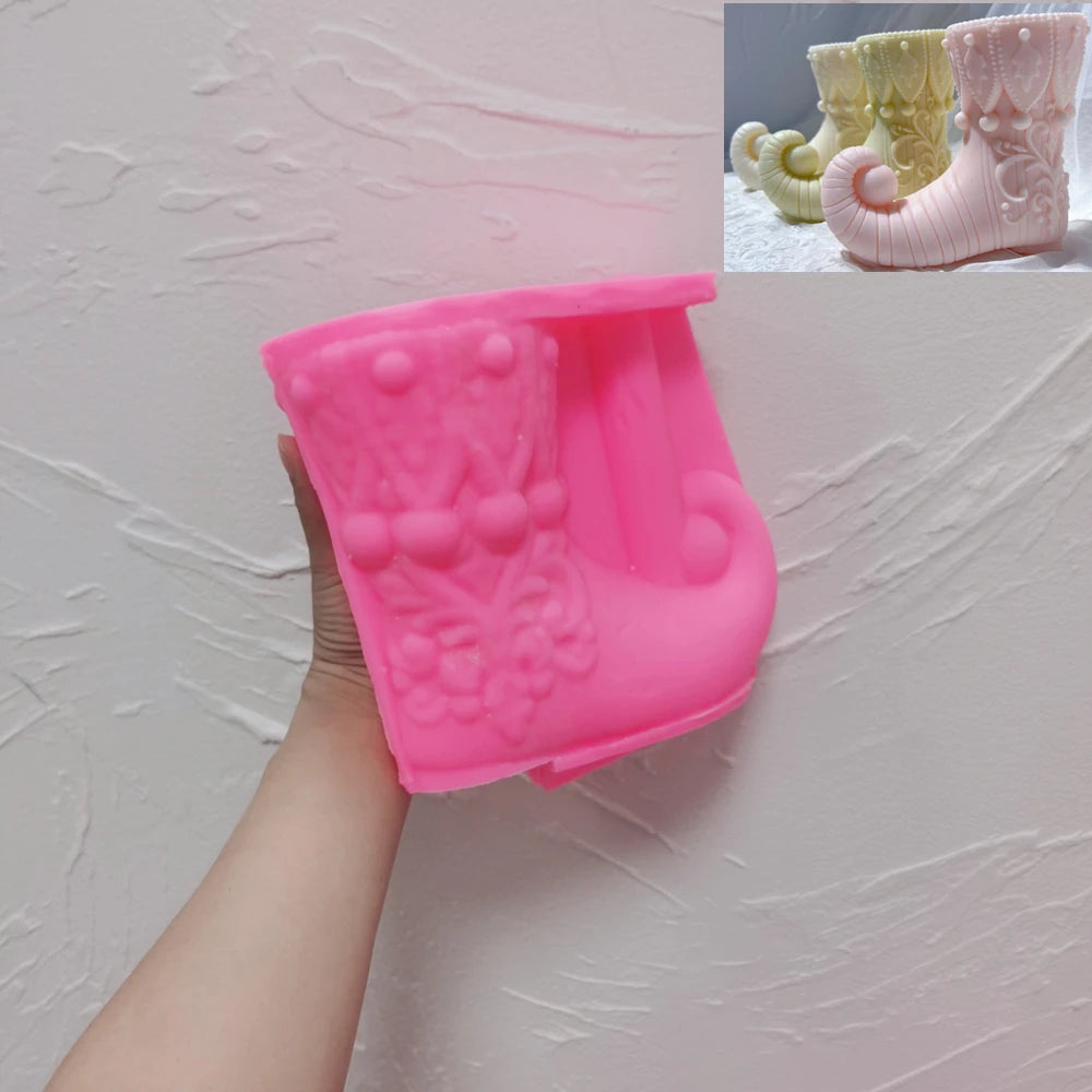 Pink silicone elf boot mold held in one hand