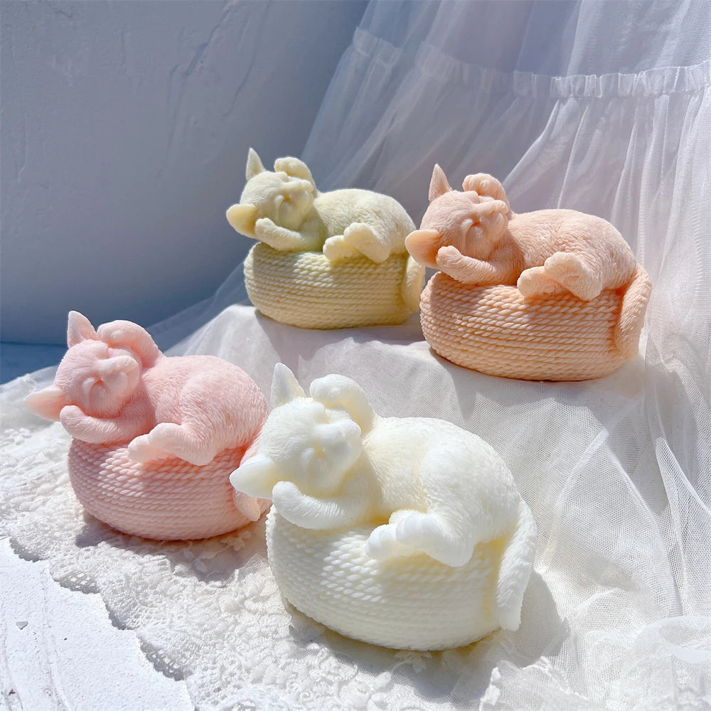 Sleeping cat candle castings curled on round textured baskets