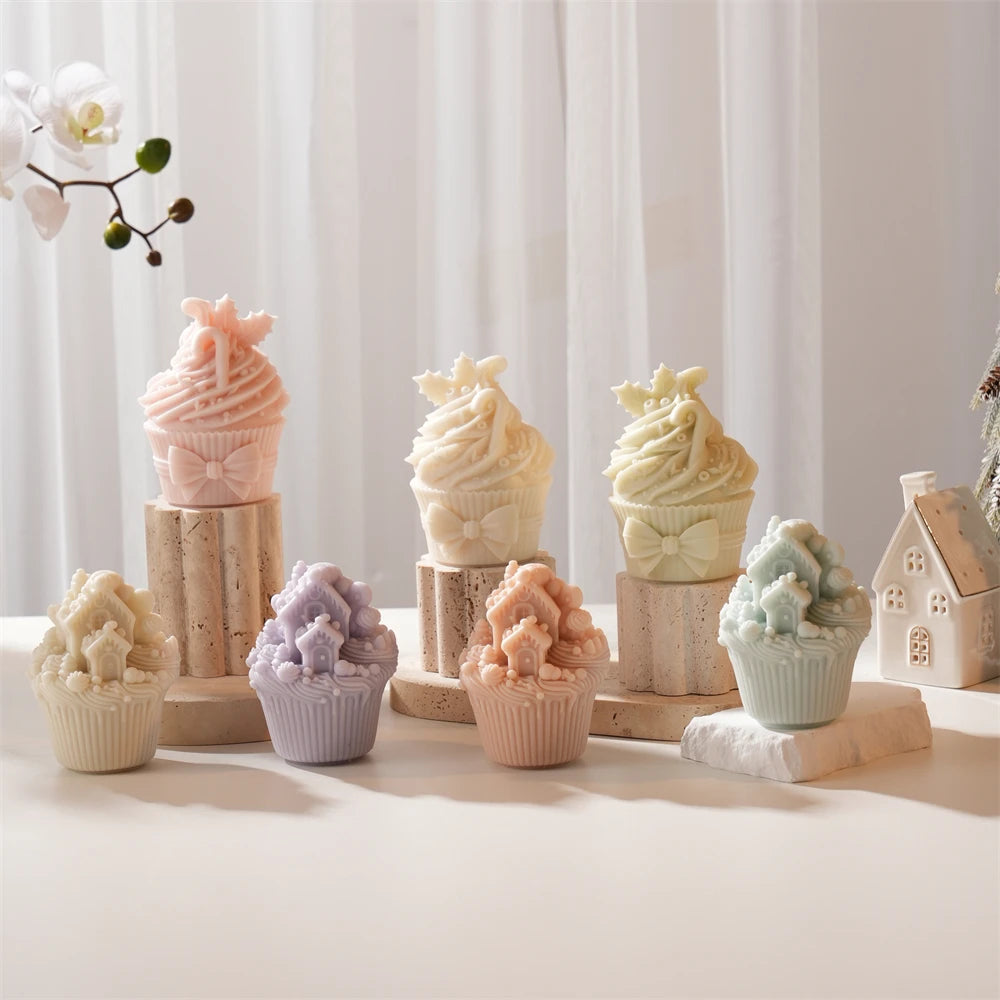 Bow and snowy-house cupcake candle designs on wooden stands
