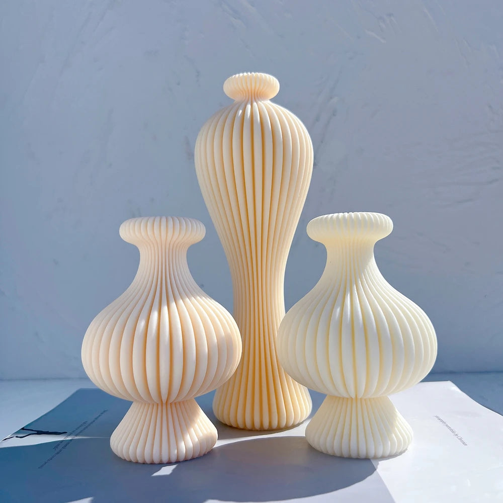 Tall ribbed figure beside two short bulbous vase-shaped castings