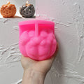 Pink ghost-topped pumpkin silicone mold held in one hand
