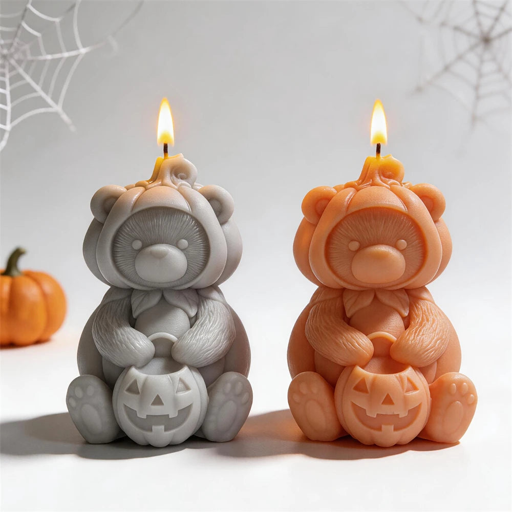 Gray and orange seated bears wearing pumpkin hoods