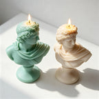 Overhead angled view of classical bust candles on pedestal bases