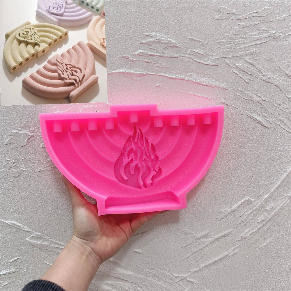 Pink silicone mold with nine upper openings for the curved Hanukkah menorah design