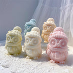 Front view of winter owl candles with round eyes, small feet and textured scarves