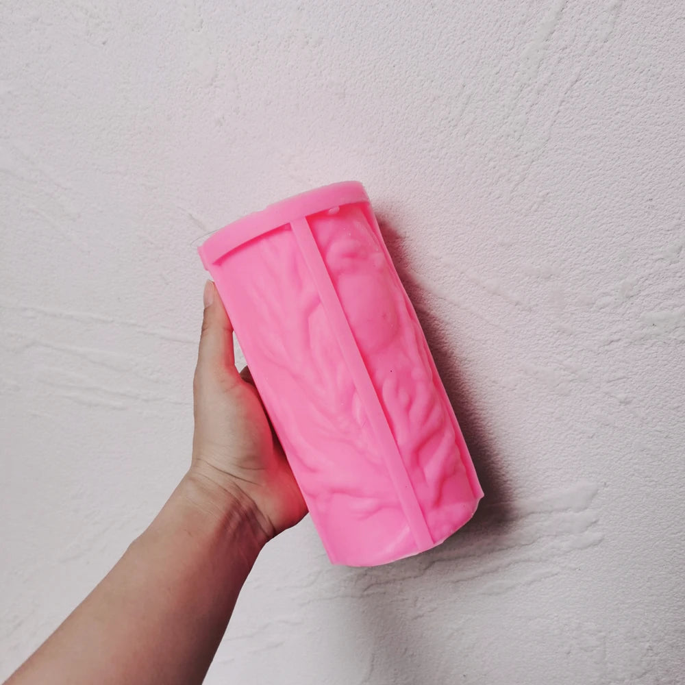 Pink moon-tree silicone candle mold held in one hand