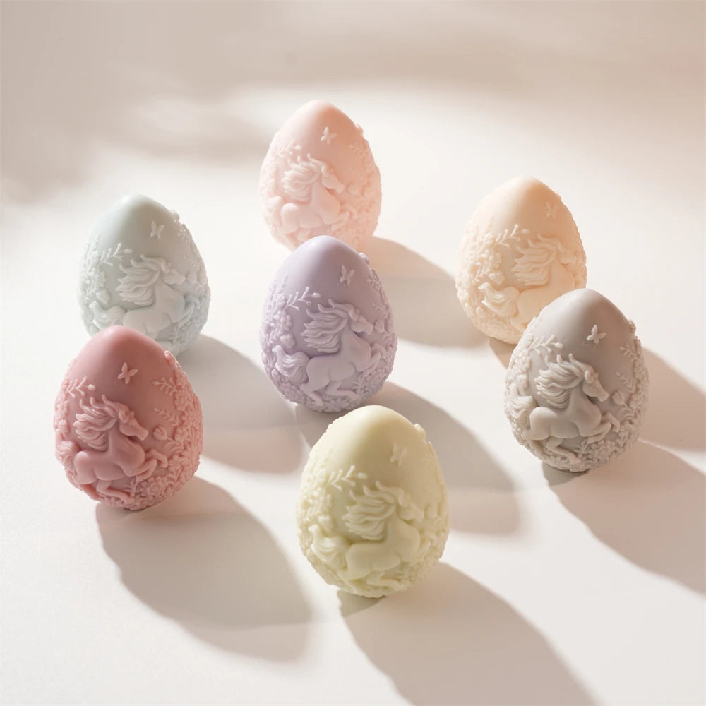 Pastel horse-relief Easter egg candles arranged on white surface