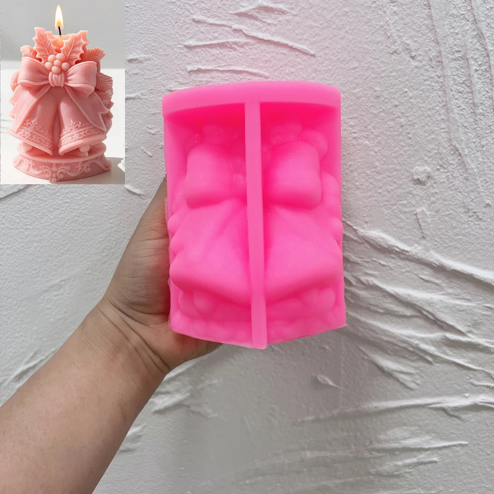 Pink silicone Christmas bells and ribbon mold held in a hand