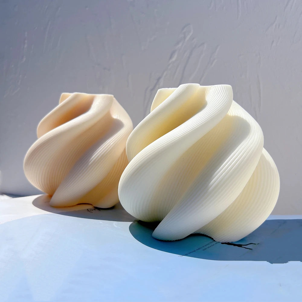 Angled view of two broad folded spiral castings