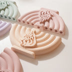 Cream and peach menorah castings laid flat to show curved branches and openings