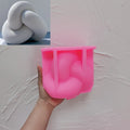Pink silicone tube knot mold held beneath a casting example